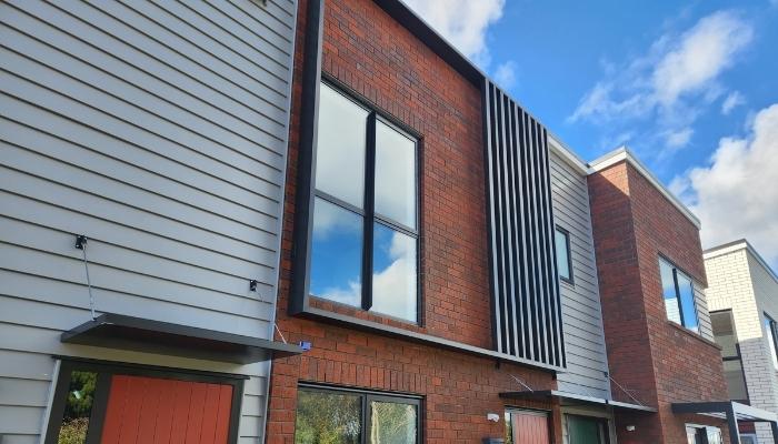 Brick townhouse with window shroud and louvres